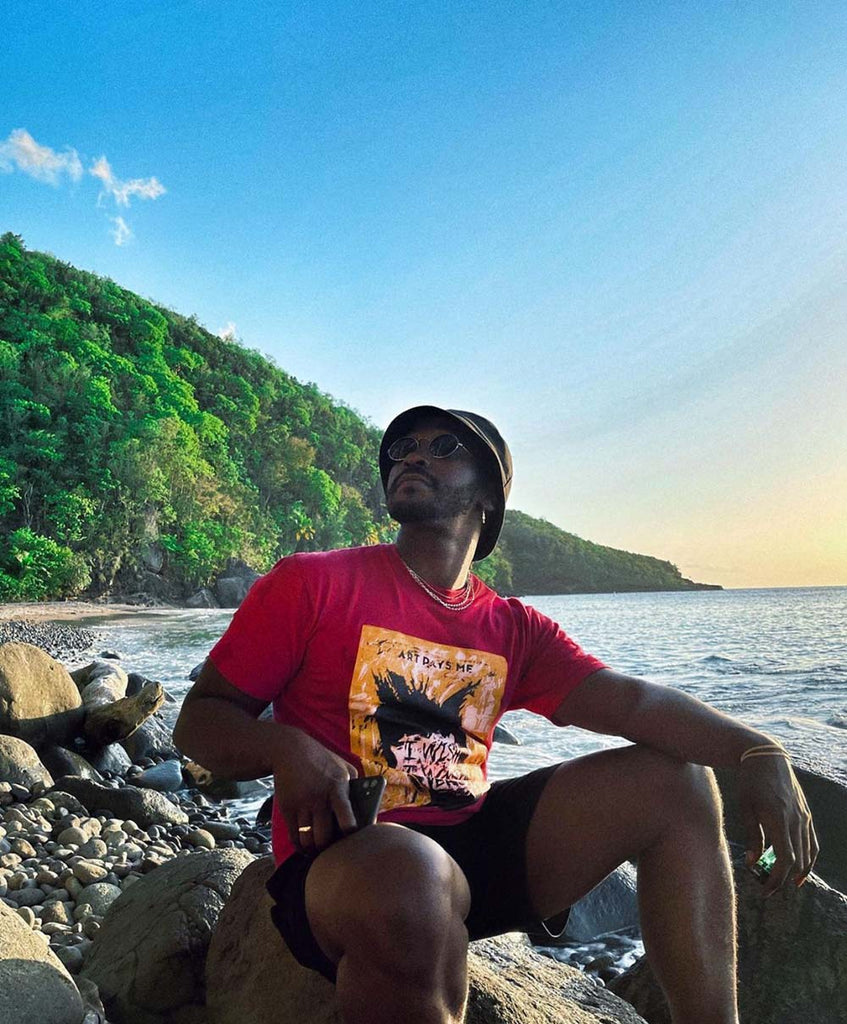Kayo in Saint Lucia wearing a Berry coloured t-shirt with a portrait of Jean-Michel Basquiat 