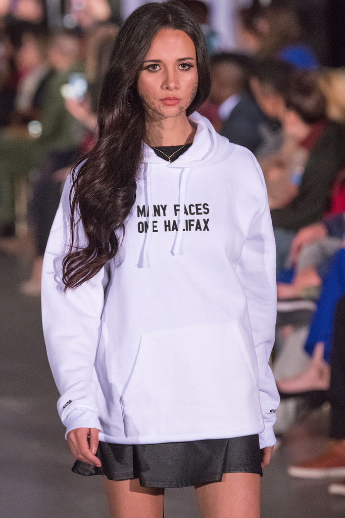 White woman wearing a white hoodie in a fashion show