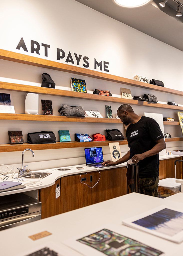 Duane wearing the Many Faces One Halifax Tee at Halifax Shopping Centre during an Art Pays Me and HaliTube pop-up event. Photo by Emma Lomas.